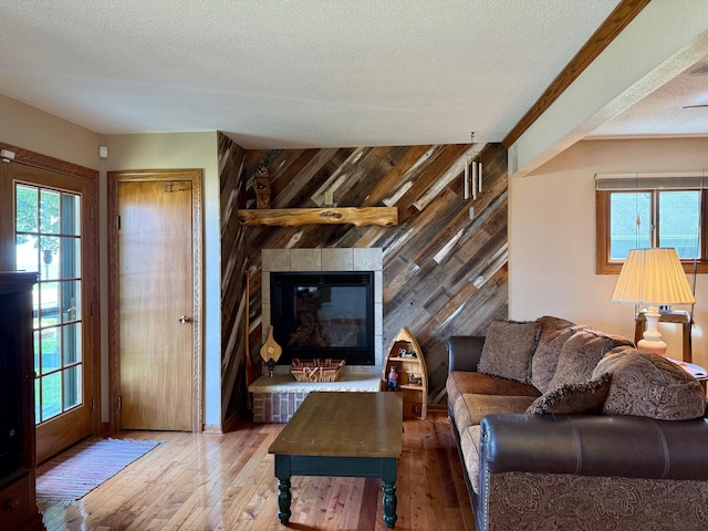 15467 Twilight Rd, Onamia, MN 56359 - living area featuring a textured ceiling, a large fireplace, hardwood / wood-style flooring, healthy amount of natural light, and wood walls