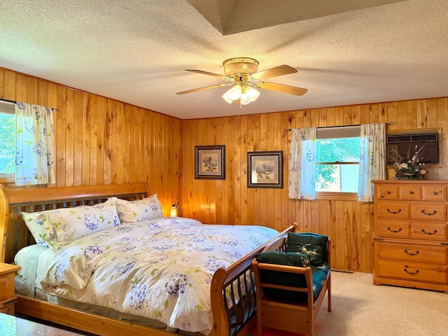 15467 Twilight Rd, Onamia, MN 56359 - bedroom with wooden walls, light colored carpet, a textured ceiling, a wall mounted AC, and ceiling fan