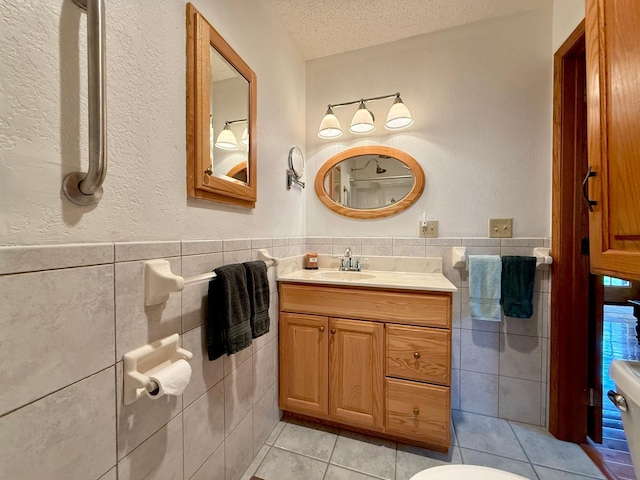 15467 Twilight Rd, Onamia, MN 56359 - bathroom with tile walls, tile patterned flooring, a textured ceiling, vanity, and wainscoting