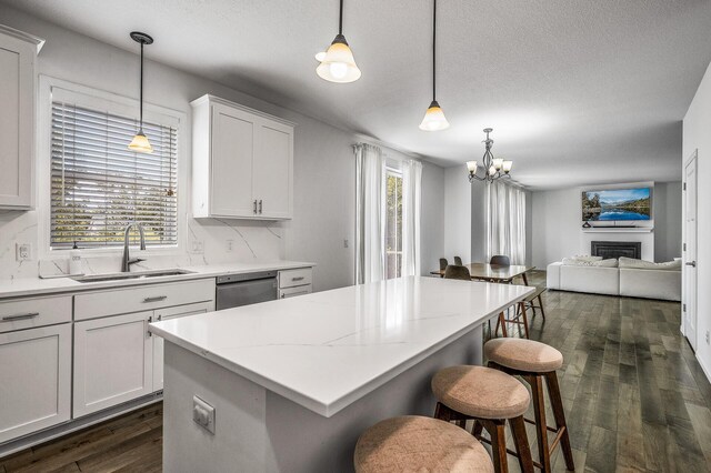 7804 Stafford Trl, Savage, MN 55378 - kitchen with stainless steel dishwasher, dark wood-style floors, open floor plan, a chandelier, and a kitchen island