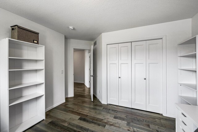 7804 Stafford Trl, Savage, MN 55378 - unfurnished bedroom with dark wood finished floors, a closet, and a textured ceiling