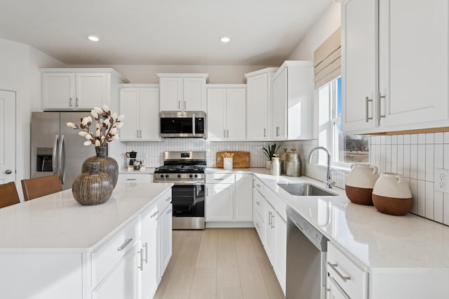 18695 Kennedy St NW, Elk River, MN 55330 - kitchen with stainless steel appliances, white cabinets, decorative backsplash, and recessed lighting