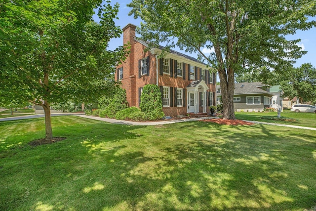 426 Armstrong Ave, Litchfield, MN 55355 - view of front of house featuring a chimney, brick siding, and a front yard