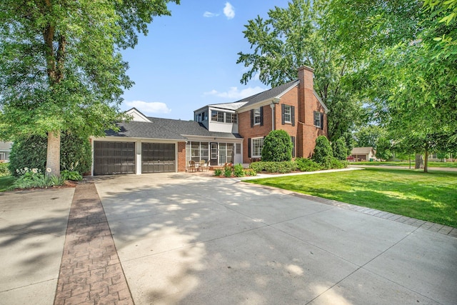 426 Armstrong Ave, Litchfield, MN 55355 - traditional-style house featuring brick siding, a garage, concrete driveway, a front yard, and a chimney