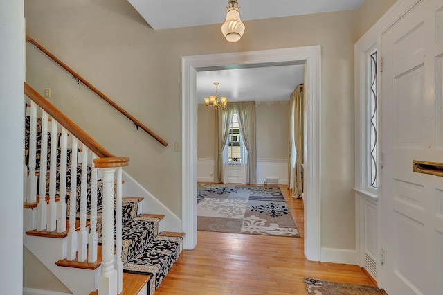 426 Armstrong Ave, Litchfield, MN 55355 - foyer entrance with light wood-type flooring, stairs, and a chandelier