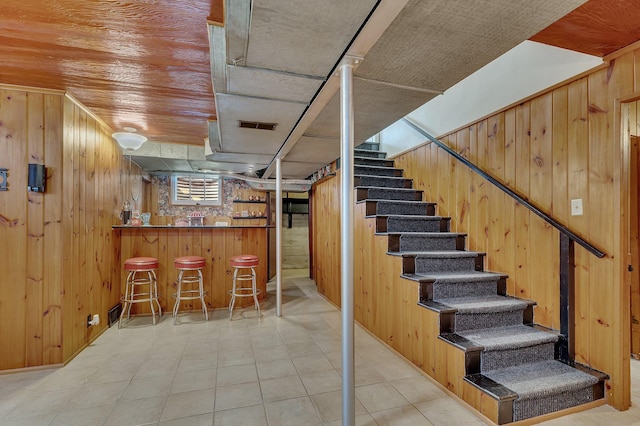 426 Armstrong Ave, Litchfield, MN 55355 - basement featuring a bar, wood walls, and stairs