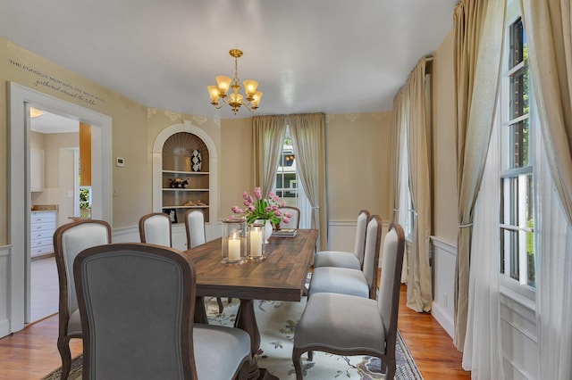 426 Armstrong Ave, Litchfield, MN 55355 - dining area featuring a chandelier, light wood-style flooring, and a wainscoted wall
