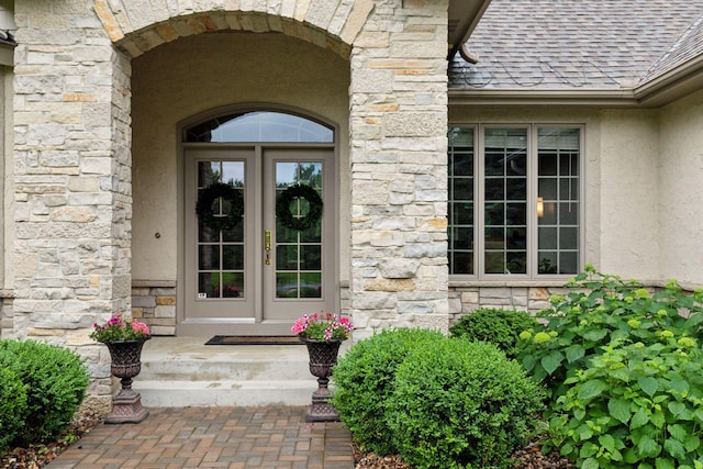 100 River Bluff Pl NW, Rochester, MN 55901 - property entrance with stone siding, french doors, stucco siding, and a shingled roof