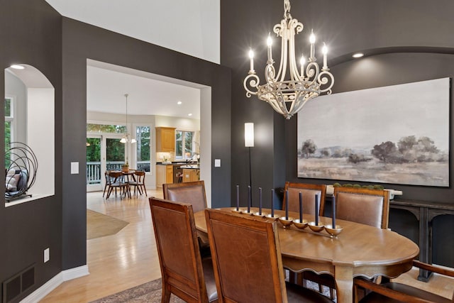 100 River Bluff Pl NW, Rochester, MN 55901 - dining room with arched walkways, a high ceiling, a chandelier, light wood-type flooring, and recessed lighting