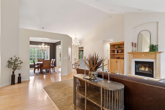 100 River Bluff Pl NW, Rochester, MN 55901 - living room with a chandelier, light wood-style flooring, a fireplace, and high vaulted ceiling