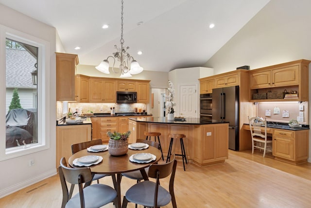100 River Bluff Pl NW, Rochester, MN 55901 - kitchen with black appliances, a center island, a chandelier, decorative backsplash, and dark countertops