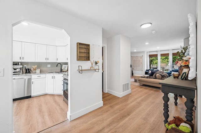 1575 Wayzata Blvd Unit A, Long Lake, MN 55356 - kitchen with appliances with stainless steel finishes, light wood-style flooring, open floor plan, white cabinets, and recessed lighting