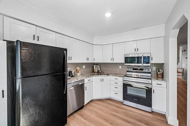 1575 Wayzata Blvd Unit A, Long Lake, MN 55356 - kitchen with appliances with stainless steel finishes, crown molding, light wood-style flooring, white cabinetry, and light stone countertops