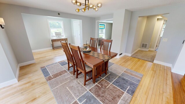 410 Atlantic Ave W, Grove City, MN 56243 - dining space with hardwood / wood-style floors, a chandelier, and healthy amount of natural light