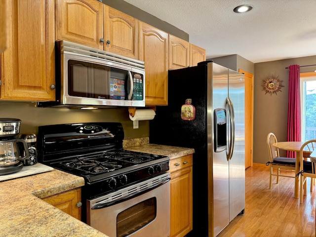 18611 327th Ave, Isle, MN 56342 - kitchen with appliances with stainless steel finishes, light countertops, light wood finished floors, and a textured ceiling