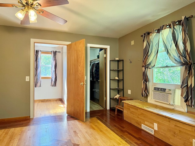 18611 327th Ave, Isle, MN 56342 - unfurnished bedroom featuring wood finished floors, a walk in closet, and a ceiling fan