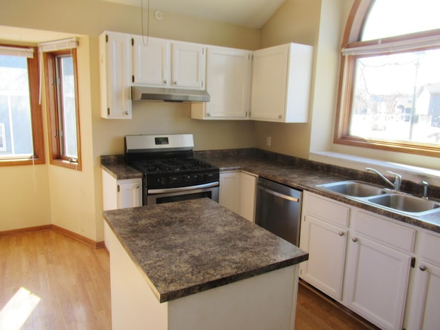 13437 Zarthan Ave S, Savage, MN 55378 - kitchen featuring appliances with stainless steel finishes, under cabinet range hood, light wood-style floors, dark countertops, and white cabinets