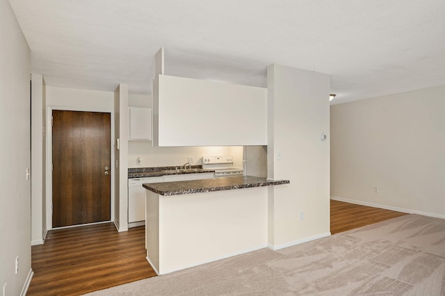 4130 Rahn Rd Unit 310, Eagan, MN 55122 - kitchen featuring white appliances, white cabinetry, dark stone countertops, a peninsula, and dark wood finished floors
