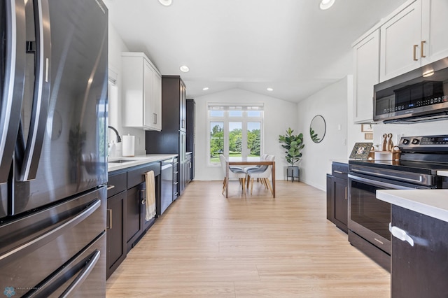 421 2nd Ave S, Kindred, ND 58051 - kitchen with stainless steel appliances, vaulted ceiling, light countertops, light wood finished floors, and white cabinetry
