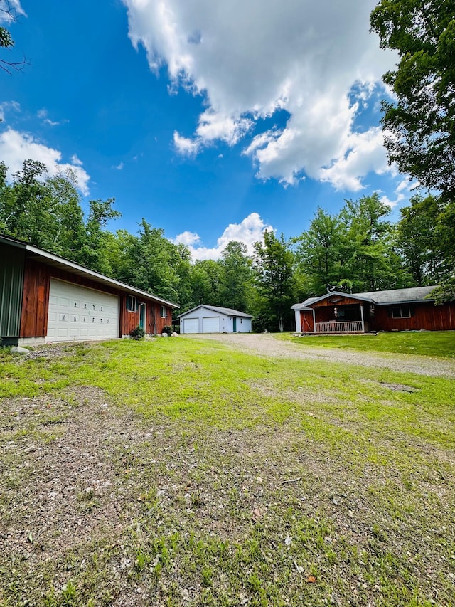 1414 E Shore Dr, Edgewater, WI 54817 - view of grassy yard featuring a garage, an outbuilding, and view of wooded area