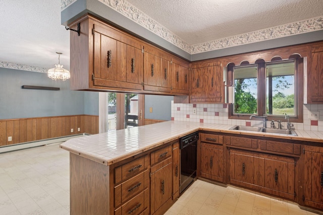 29908 108th St NW, Baldwin Twp, MN 55371 - kitchen featuring dishwasher, a textured ceiling, a peninsula, a wainscoted wall, and brown cabinets