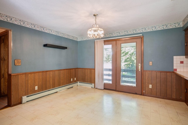29908 108th St NW, Baldwin Twp, MN 55371 - unfurnished dining area with wainscoting, wood walls, a chandelier, tile patterned floors, and baseboard heating
