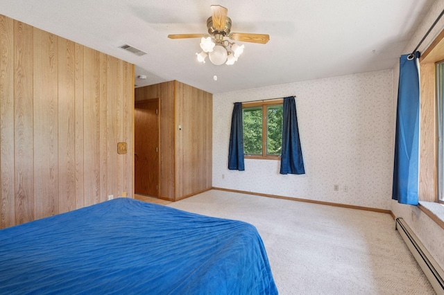 29908 108th St NW, Baldwin Twp, MN 55371 - carpeted bedroom featuring a baseboard heating unit, wallpapered walls, wooden walls, and a ceiling fan