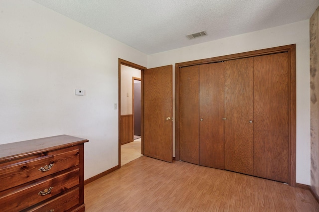 29908 108th St NW, Baldwin Twp, MN 55371 - unfurnished bedroom featuring light wood finished floors, a closet, and a textured ceiling