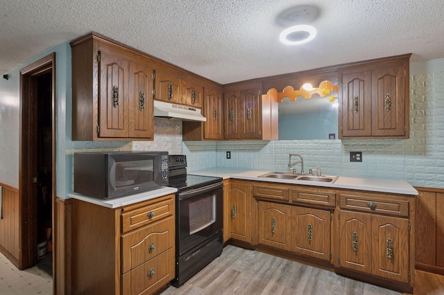 29908 108th St NW, Baldwin Twp, MN 55371 - kitchen with black appliances, under cabinet range hood, a textured ceiling, light countertops, and brown cabinetry