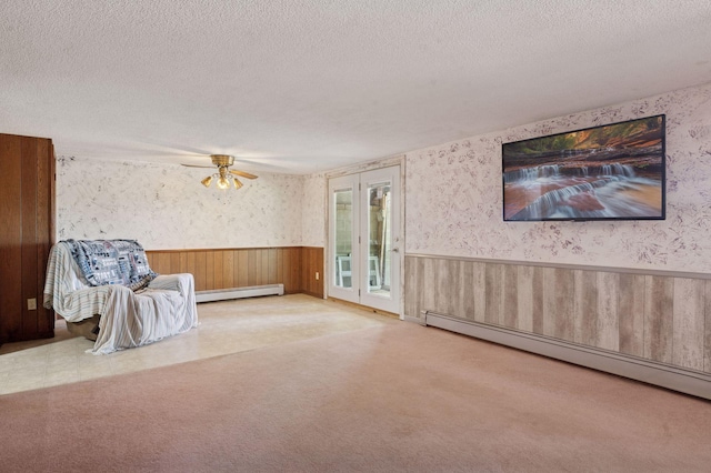 29908 108th St NW, Baldwin Twp, MN 55371 - unfurnished room featuring a baseboard radiator, wainscoting, a textured ceiling, wallpapered walls, and carpet flooring
