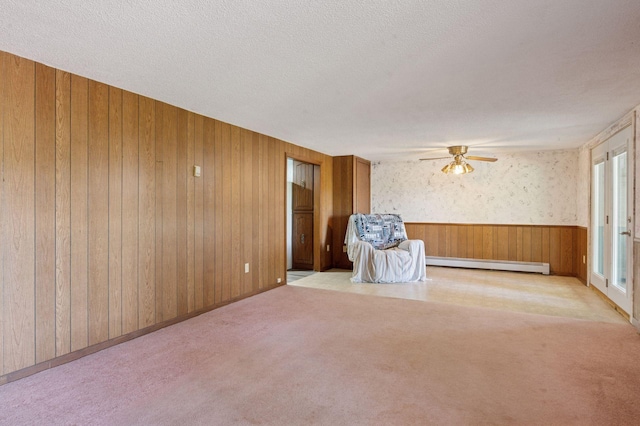 29908 108th St NW, Baldwin Twp, MN 55371 - unfurnished room with a baseboard radiator, ceiling fan, carpet, wooden walls, and a textured ceiling