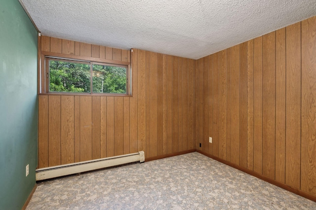 29908 108th St NW, Baldwin Twp, MN 55371 - spare room with baseboard heating, wood walls, and a textured ceiling
