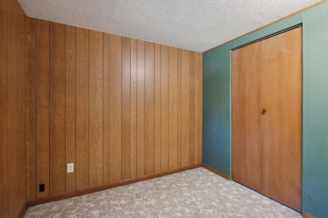 29908 108th St NW, Baldwin Twp, MN 55371 - unfurnished bedroom with a textured ceiling, wood walls, and a closet