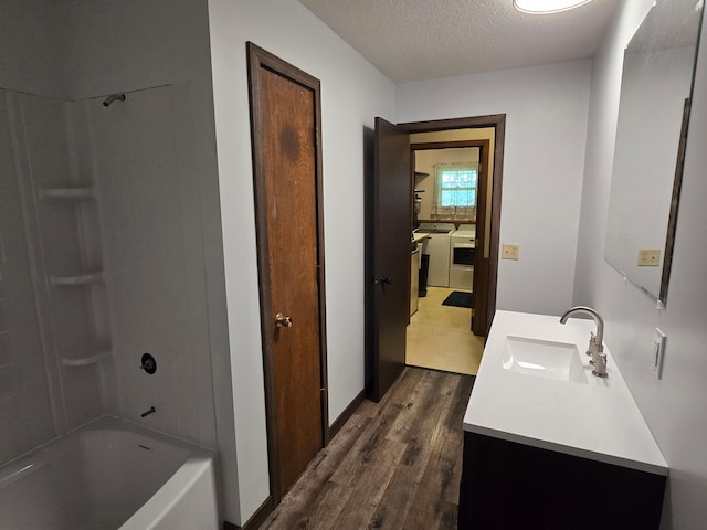 29908 108th St NW, Baldwin Twp, MN 55371 - full bathroom featuring wood finished floors, washing machine and dryer, vanity, a textured ceiling, and shower / bath combination