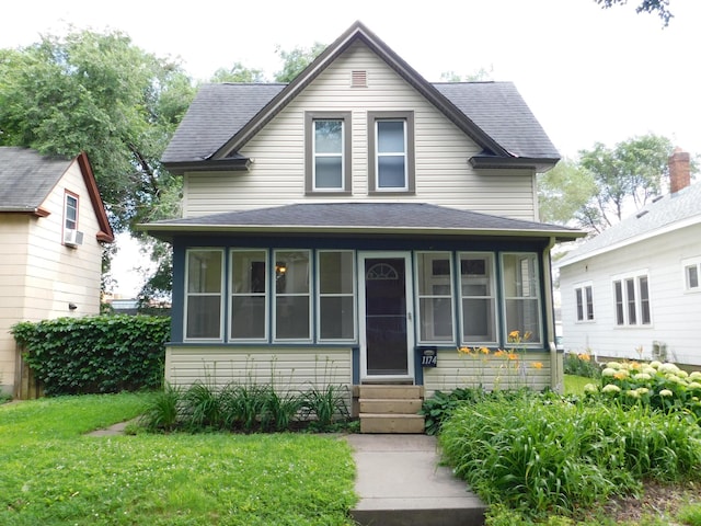 1174 Sherburne Ave, Saint Paul, MN 55104 - view of front of house featuring entry steps, a sunroom, a shingled roof, and a front lawn