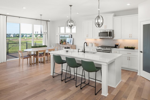 14643 107th Pl N, Maple Grove, MN 55369 - kitchen with stainless steel appliances, a chandelier, decorative backsplash, a breakfast bar, and recessed lighting