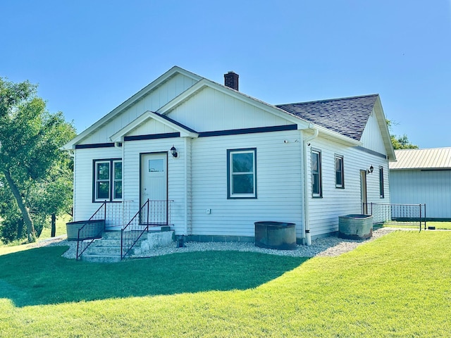 1555 US Highway 75, Lake Benton Twp, MN 56149 - view of front of house featuring a chimney, a shingled roof, and a front lawn