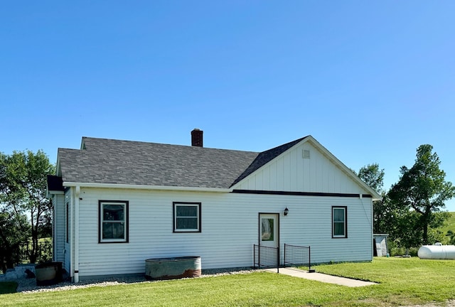 1555 US Highway 75, Lake Benton Twp, MN 56149 - back of property featuring a chimney, a yard, a shingled roof, and board and batten siding