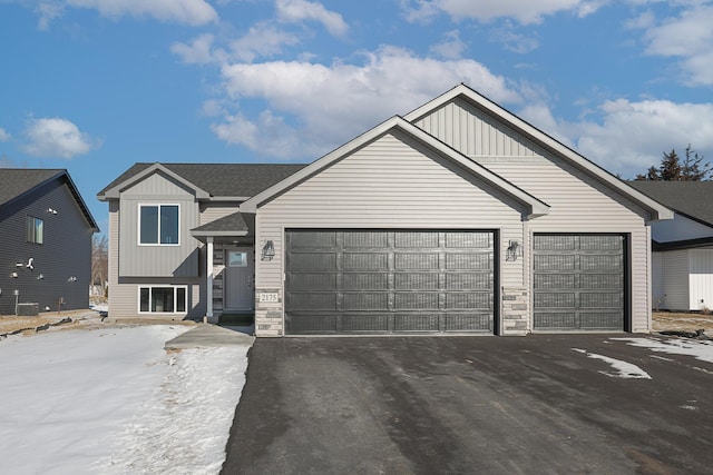 12051 Owatonna Ct, Blaine, MN 55449 - view of front of house with a garage, driveway, a shingled roof, and board and batten siding