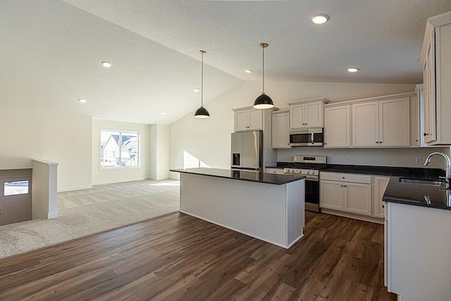 12051 Owatonna Ct, Blaine, MN 55449 - kitchen featuring appliances with stainless steel finishes, lofted ceiling, dark wood-type flooring, open floor plan, and a center island