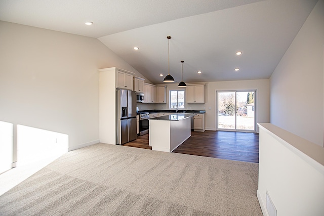 12051 Owatonna Ct, Blaine, MN 55449 - kitchen featuring appliances with stainless steel finishes, dark colored carpet, open floor plan, vaulted ceiling, and a kitchen island