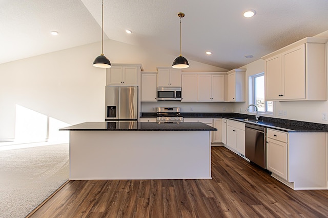 12051 Owatonna Ct, Blaine, MN 55449 - kitchen featuring appliances with stainless steel finishes, vaulted ceiling, dark wood-style flooring, a center island, and pendant lighting