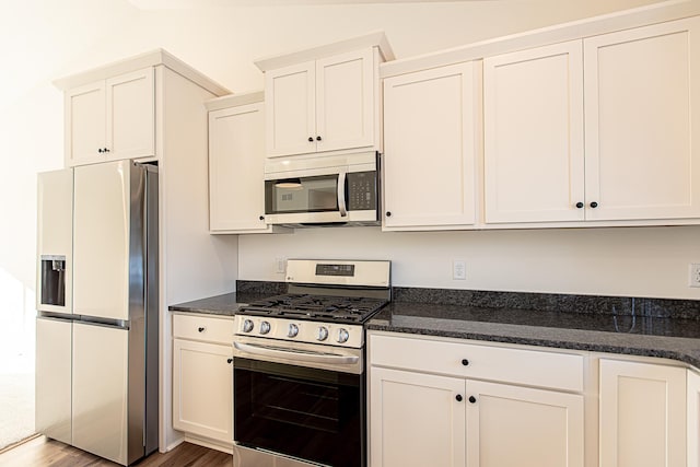 12051 Owatonna Ct, Blaine, MN 55449 - kitchen featuring stainless steel appliances, white cabinets, dark stone countertops, and wood finished floors