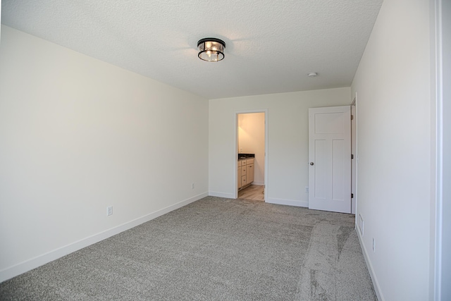 12051 Owatonna Ct, Blaine, MN 55449 - unfurnished bedroom with light carpet, a textured ceiling, and connected bathroom