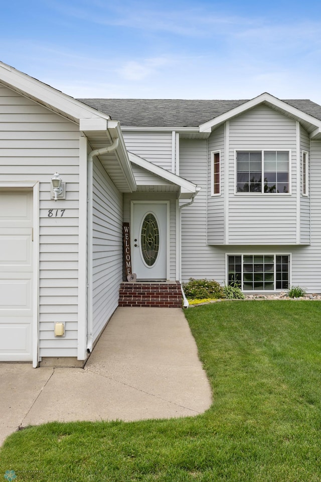 817 16th Avenue Ct W, West Fargo, ND 58078 - doorway to property with an attached garage, a yard, and roof with shingles