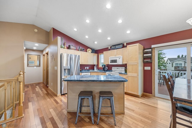 817 16th Avenue Ct W, West Fargo, ND 58078 - kitchen with white appliances, lofted ceiling, a kitchen island, light brown cabinets, and light wood-style floors