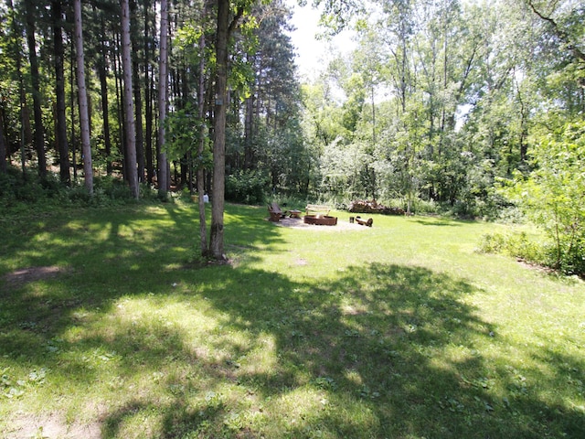 237 Plainview Dr, Troy Twp, WI 54022 - view of green lawn with a fire pit and a wooded view