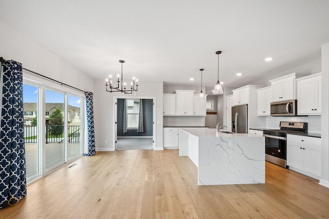 14221 Aspen Ave, Rosemount, MN 55068 - kitchen with appliances with stainless steel finishes, backsplash, a chandelier, light wood finished floors, and white cabinetry