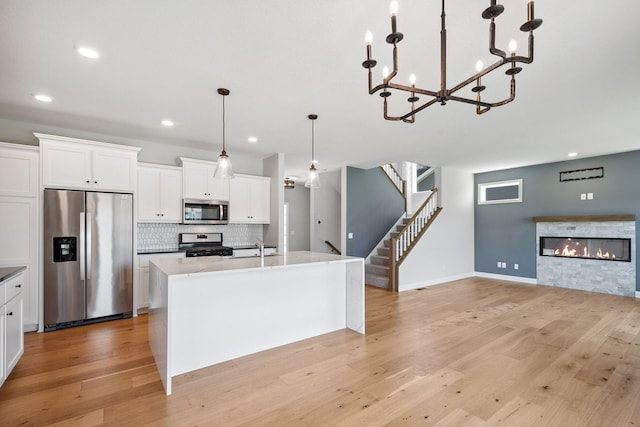 14221 Aspen Ave, Rosemount, MN 55068 - kitchen with appliances with stainless steel finishes, open floor plan, light wood finished floors, recessed lighting, and tasteful backsplash