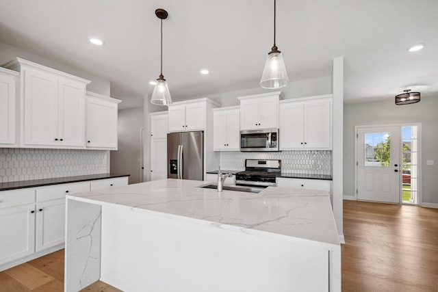14221 Aspen Ave, Rosemount, MN 55068 - kitchen with appliances with stainless steel finishes, decorative backsplash, light wood-type flooring, recessed lighting, and a center island with sink